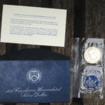 Eisenhower dollar and blue folder