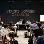 Students in a room with two instructors at the front and "Stack's Bowers Galleries" on the wall behind them.