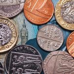 U.K. coins against a five pound U.K. banknote
