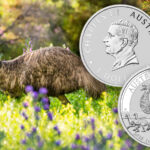 An emu in a field beside the Australian silver $1