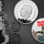 The Royal Mint Iron Maiden coin on a black background with a guitar