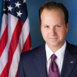 Paul Hollis in front of an American flag