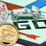 The Royal Mint Monopoly commemorative silver and gold coins on a Monopoly board