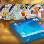 The six silver Disney and Pixar commemorative coins against a sparkly gold background